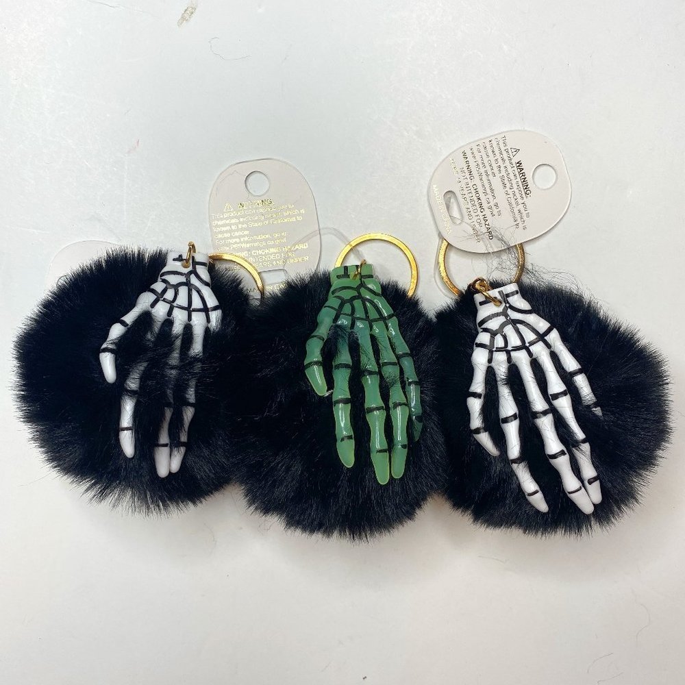 Superstar Lot of 3, NWT, black poof key chains w/ skeleton hands in white green.